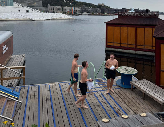 Trzech mężczyzn na pomoście w Oslo, świętujących - Marźniesz zimą w radosnej atmosferze wodnej.