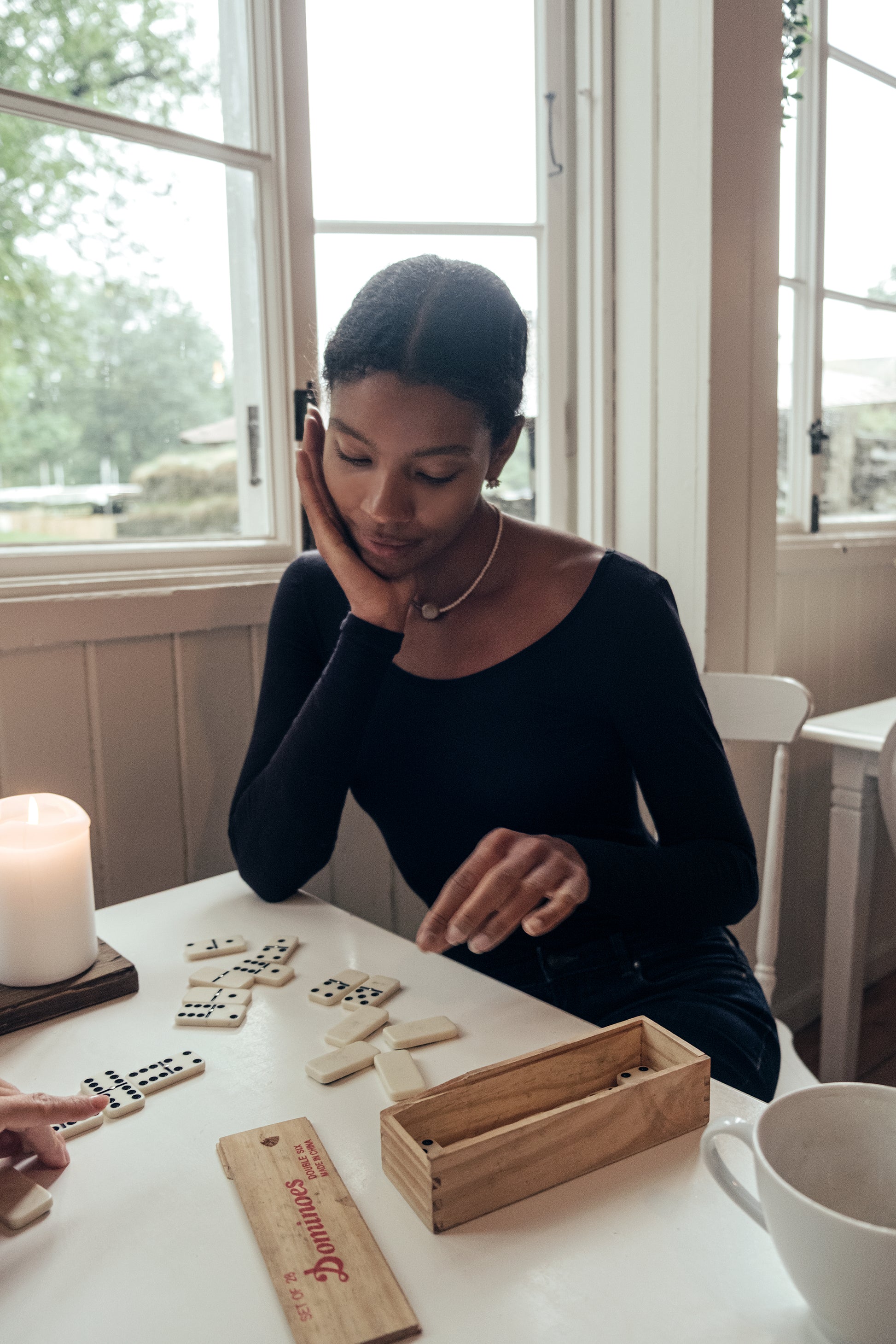 Model wearing Wełniane body Astra against a rocky background, showcasing elegant minimalism in fashion.