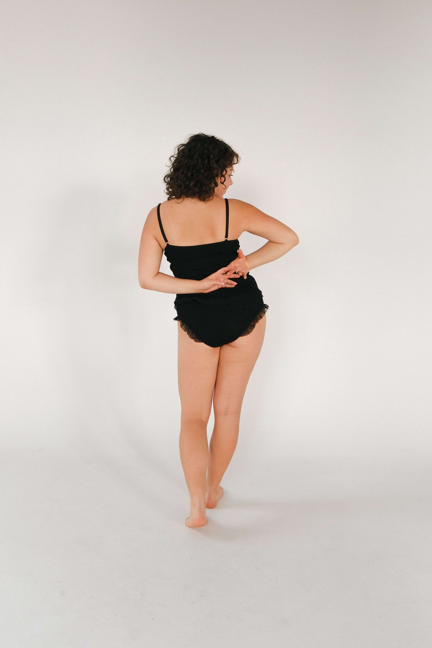 Model wearing a black Merino wool and tulle top, showcasing the back view, highlighting style and comfort.