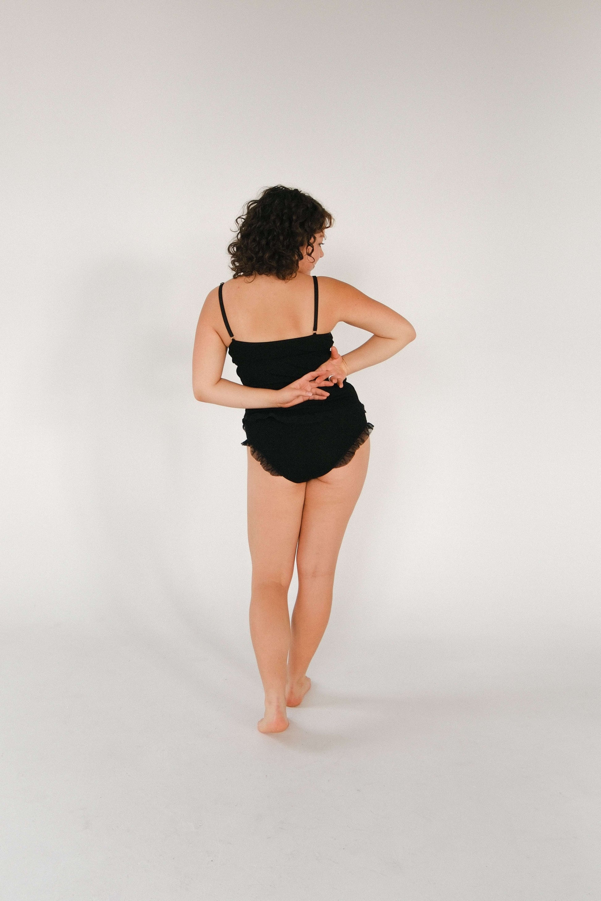 Model wearing a black Merino wool and tulle top, showcasing the back view, highlighting style and comfort.