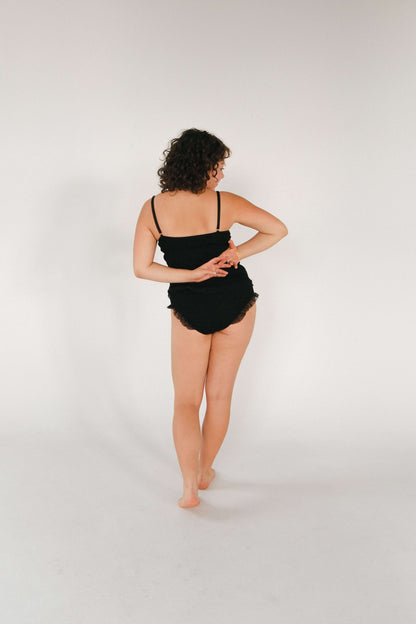 Model wearing a black Merino wool and tulle top, showcasing the back view, highlighting style and comfort.