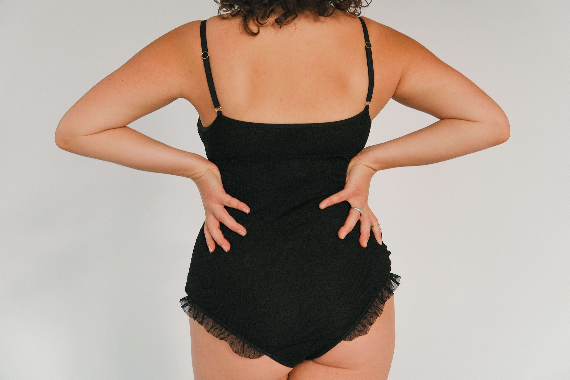 Body z wełny merino i tiulu w czarnym kolorze z tiulowymi miseczkami i delikatnymi falbankami.